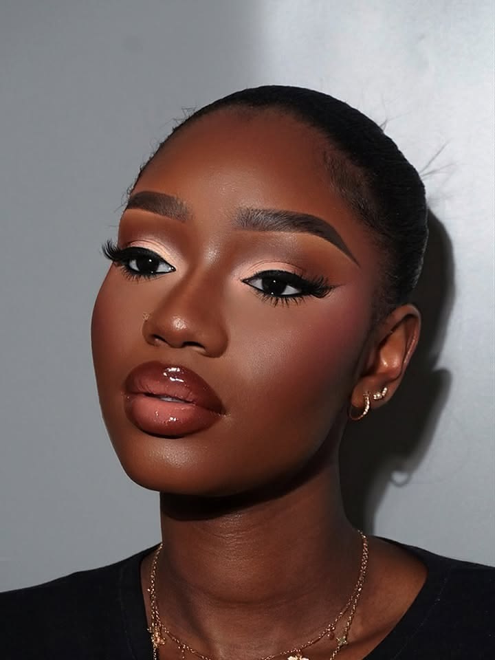 Portrait rapproché d'une femme au maquillage bronze et aux lèvres brillantes