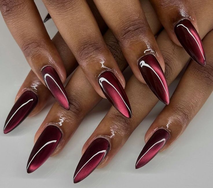 Ongles longs et pointus laqués de bordeaux brillant